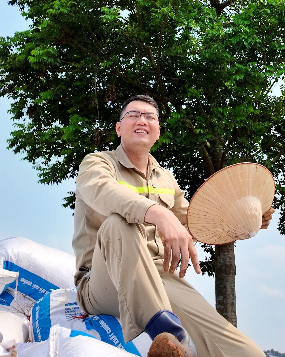 Người sáng lập TeraGreen ngồi nghỉ bên bao phân bón dưới gốc cây tại nông trại Ba Vì